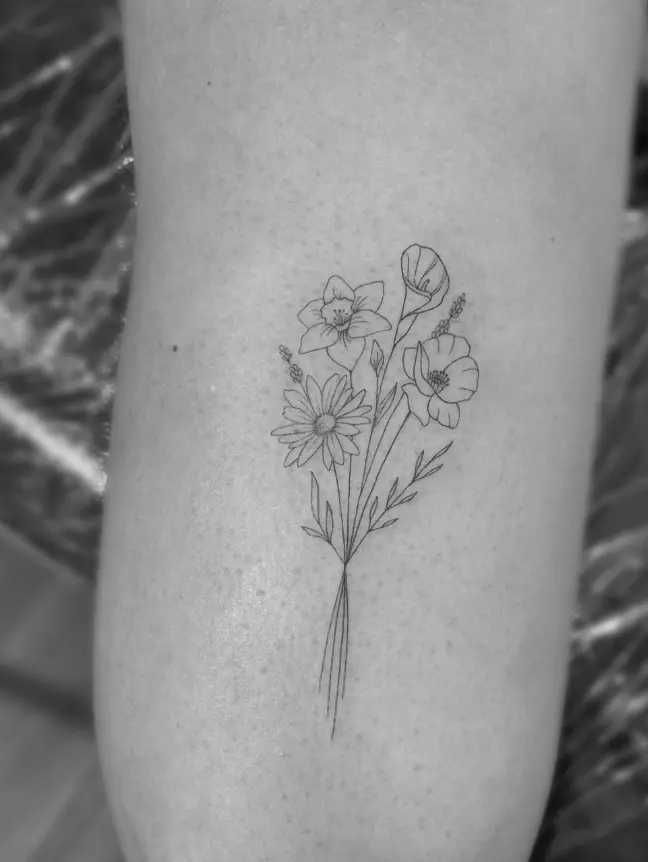 Delicate fine line flower bouquet tattoo with multiple flower types by Chelsea.Q at Omnia Tattoo Studio
